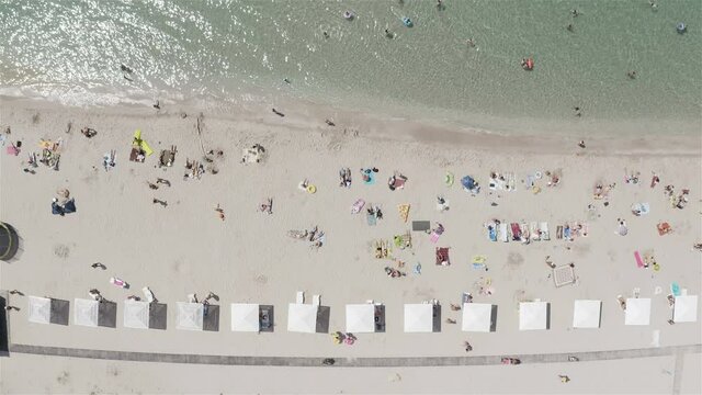 tourists sunbathe on the white sand of the sea coast.