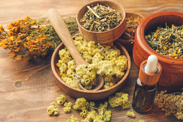 Bowls composition with different herbs on wooden background