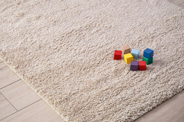 Fototapeta na wymiar Cubes on soft carpet in room, closeup