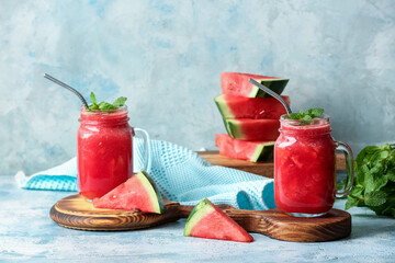Mason jars with fresh watermelon juice on color background