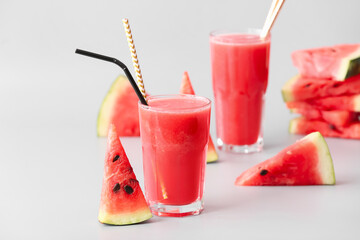 Glasses of fresh watermelon juice on light background
