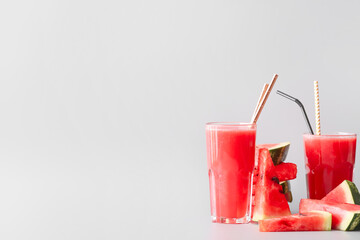 Glasses of fresh watermelon juice on light background