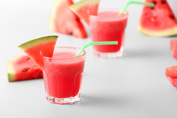 Glasses of fresh watermelon juice on light background