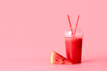 Plastic cup with fresh watermelon juice on color background