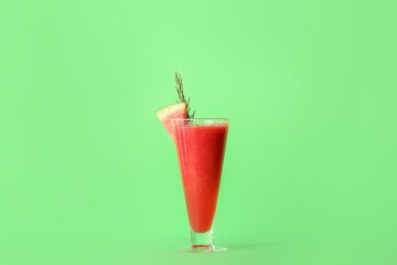 Glass of fresh watermelon juice on color background