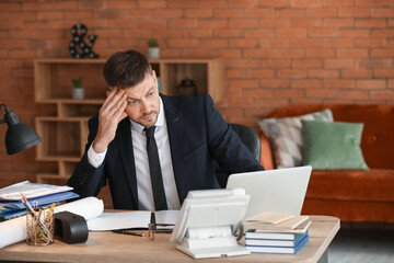 Stressed businessman trying to meet deadline in office