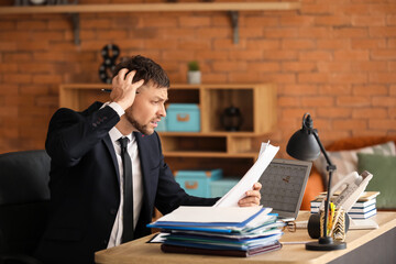 Stressed businessman trying to meet deadline in office
