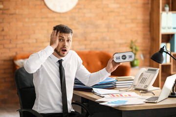 Stressed businessman trying to meet deadline in office