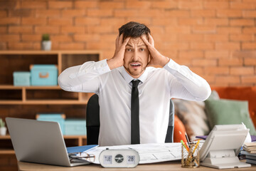 Stressed businessman trying to meet deadline in office
