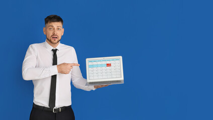 Stressed businessman with laptop on color background. Concept of deadline