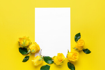 Composition with beautiful yellow roses and blank paper on color background