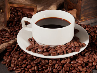 Antique vintage retro bronze coffee mill on black wooden board with roasted coffee beans