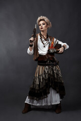 Beautiful girl in steampunk style costume with hat and handgun