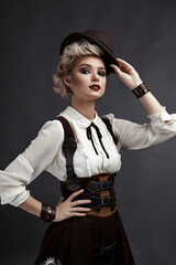 Beautiful blonde girl in steampunk style costume and earrings and necklace
