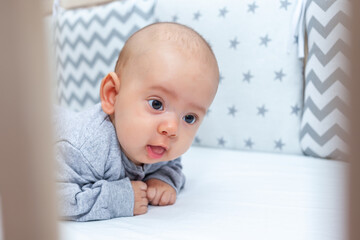 Newborn girl raises her head, physical development of babies. Selective focus