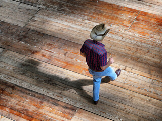High angle shot of a western man dancing traditional western folk music dances on a wooden floor