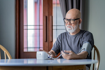 Senior man wear black glasses checking his blood pressure.