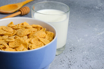 Corn flakes in a plate and milk in a glass. Healthy breakfast. Copy space