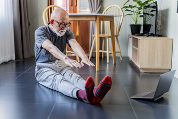 Old man exercise in the room by online trainer.