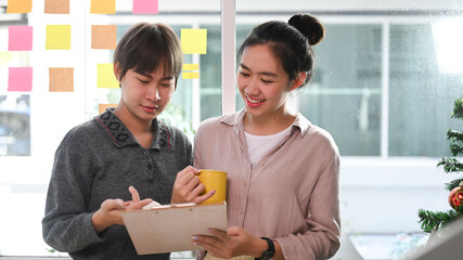 Two designers colleagues discussing new project in creative office.