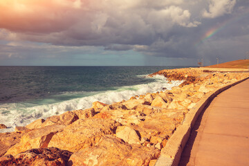 Seascape with a dramatic cloudy sky, rocky seashore. The embankment in Tel Aviv-Yafo, Israel. Harry Truman str.