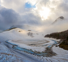 mountain valley covered by a snow in a dense clouds