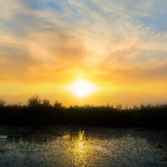 dramatic sunset with sunrays over the quiet lake