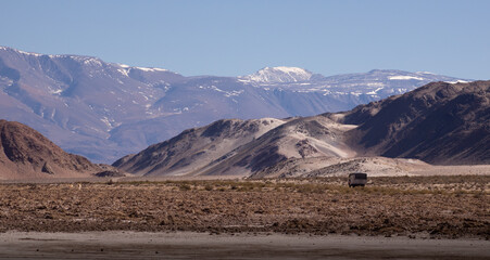 Coche viajando por la carretera hacia una enorme montaña nevada