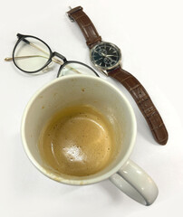 Empty coffee cup with watch and glasses on white background top view
