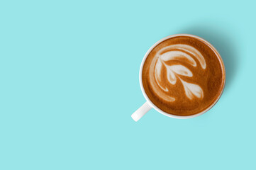 Hot latte art coffee cup on blue background. Top view