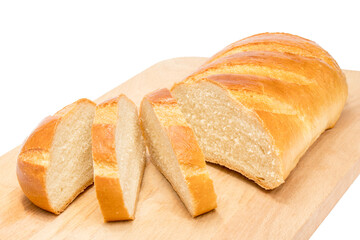 A loaf of white bread with three slices cut off lies on a wooden Board.