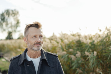 Serious man standing thinking outdoors