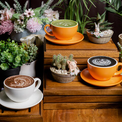 three cups of latte coffee with different flavors