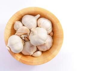 Obraz na płótnie Canvas Garlic in a wooden bowl on a white background