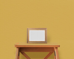 Wooden table on yellow wall with photoframe