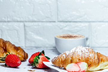 Continental breakfast with croissants. Coffee and fresh strawberries