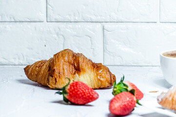 Continental breakfast with croissants. Coffee and fresh strawberries