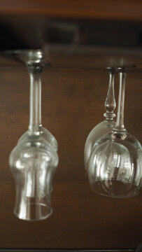 Vertical Shot Of Glasses Hanging On A Rack