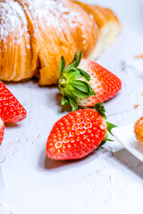 Fresh strawberries and croissant backdrop.