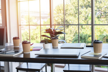 coffee in paper cup ,Laptop and notebook on wooden table in office
