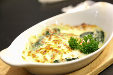 baked Spinach with Cheese on white plate - close up shot