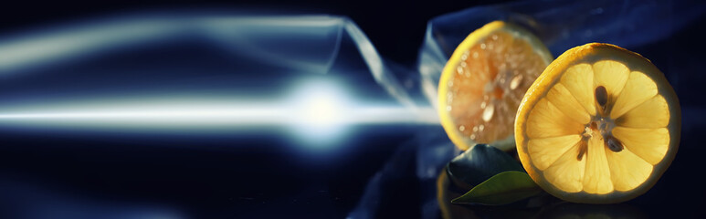 Composition with orange and grapefruit slices on a black background. A slice of orange with back light on a black background with water drops. Juicy orange on a table.