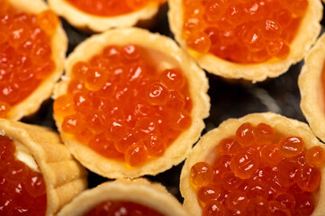 Tartlets with salmon caviar on a platter. Close-up, selective focus.
