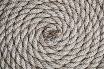 Braided thick rope tied in a skein. Hemp rope for decoration and design. Background from a fishing rope.