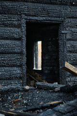 Wooden house after the fire. Coals on the logs. The ashes of the house from the fire. Burnt destroyed cottage.