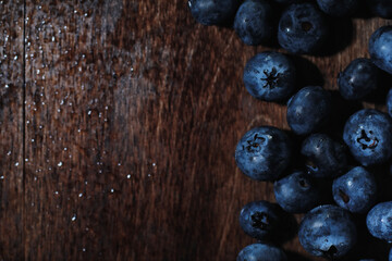 Water drops on ripe sweet blueberry. Fresh blueberries background with copy space for your text. Vegan and vegetarian concept. Macro texture of blueberry berries.