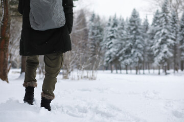 Outdoor portrait of handsome man in coat and scurf. Bearded man in the winter woods.