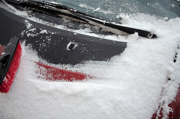 cleaning the car with a snow brush from snow