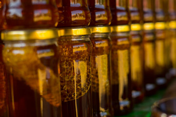honey with honeycomb in jars stocked on a shelf