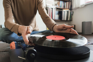 Young man listening to music, relaxing, enjoying life at home. Men wearing casual clothes having fun. Turntable playing vinyl LP record. Leisure, music, hobby, lockdown, lifestyle concept.